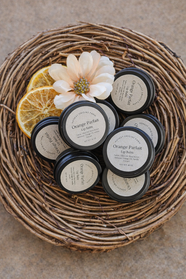 Basket of tallow lip balm with oranges and a delicate flower