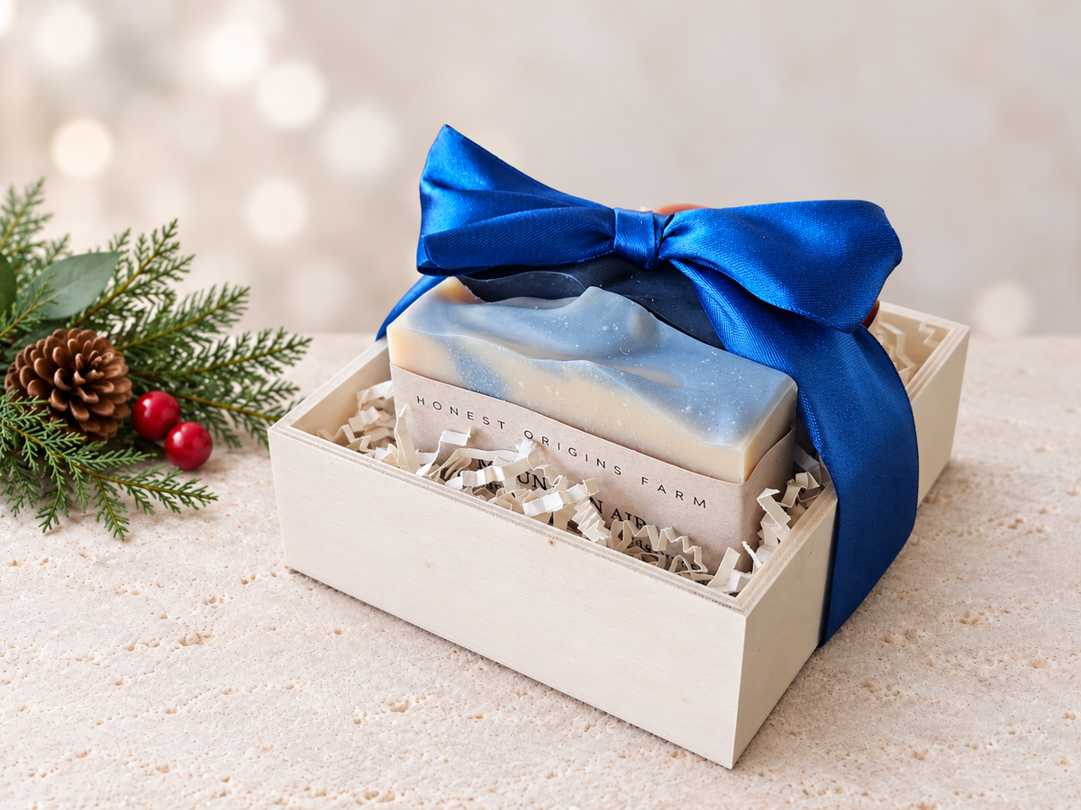 Three soaps in a wooden crate/box with a blue satin bow and Christmas accents.
