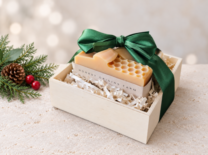 Three soaps in a wooden crate/box with a green satin bow and Christmas accents.