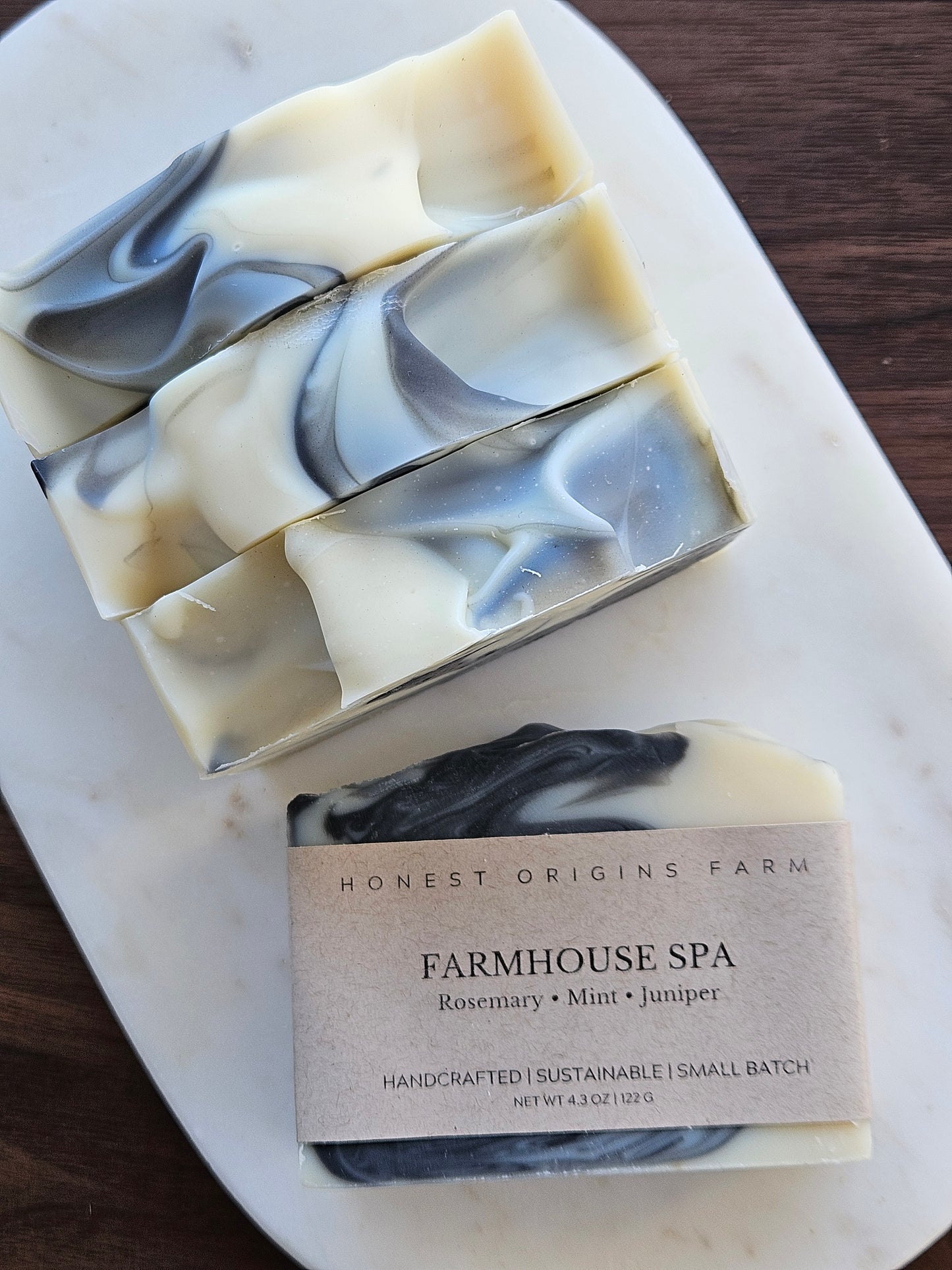 Four bars of soap with a packaging label on a marble surface